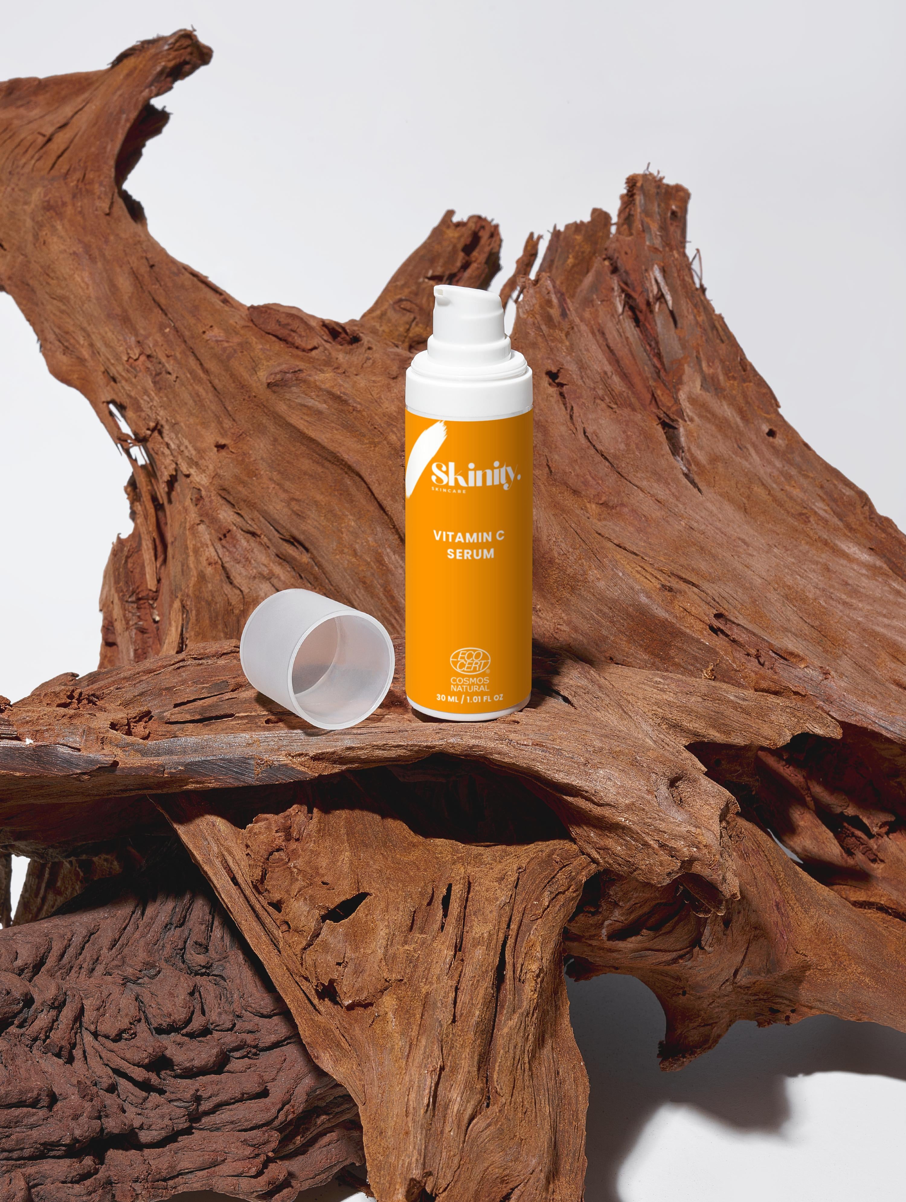 Bottle of vitamin C serum for all skincare on rustic wood background, promoting radiant complexion.