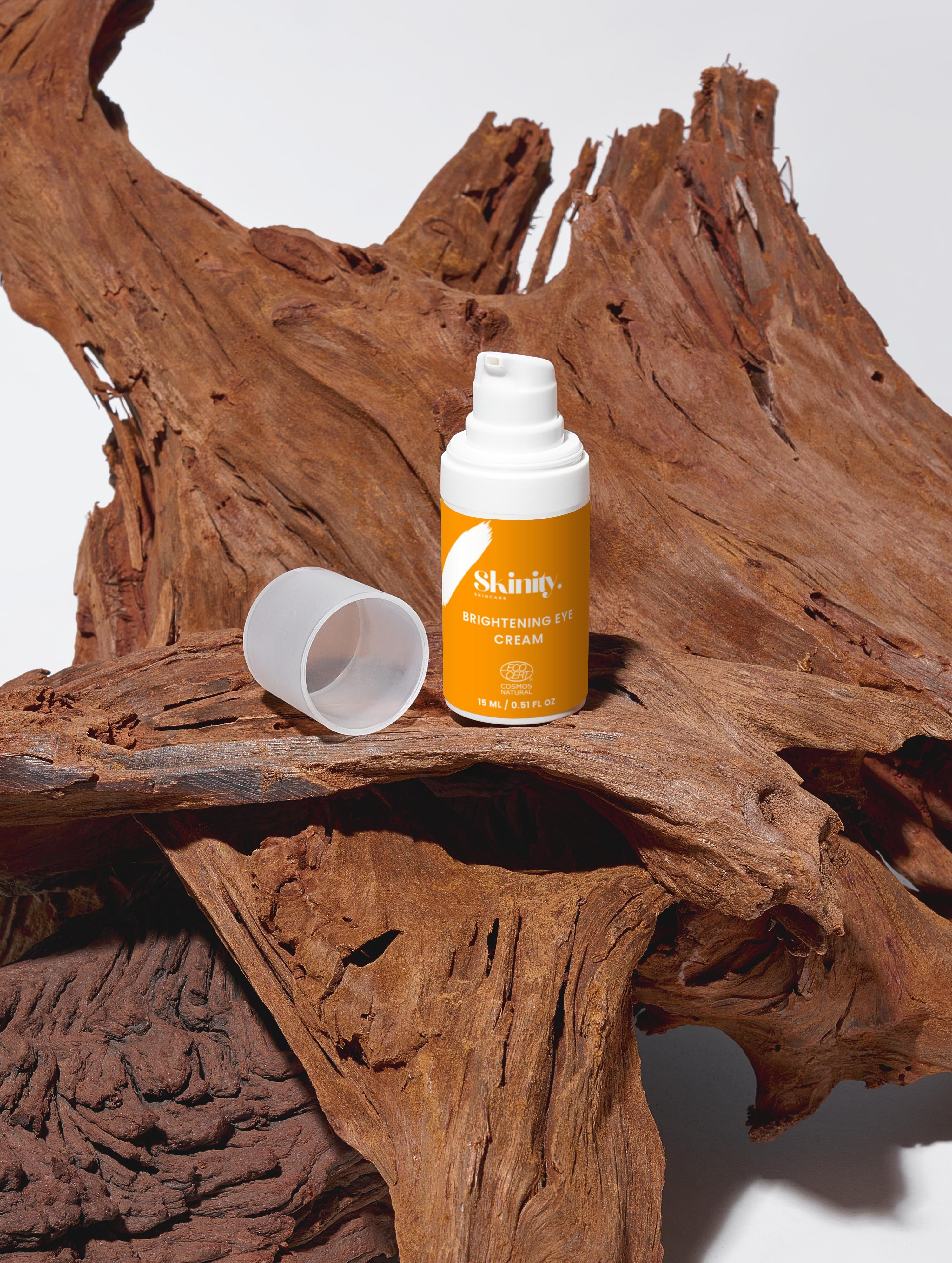 Brightening Eye Cream for All skincare bottle on wooden surface, showcasing eco-friendly packaging and natural ingredients.