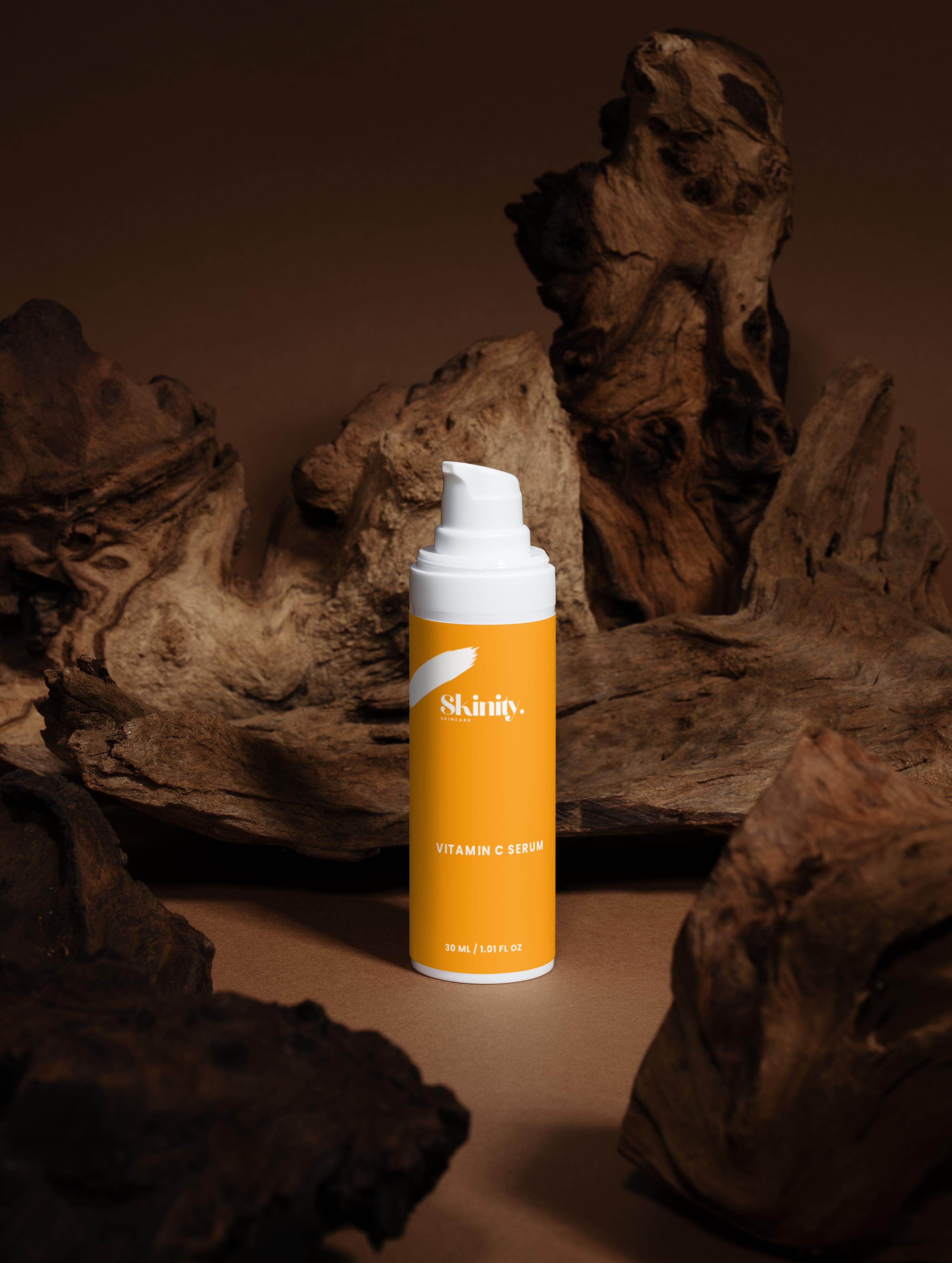 Vitamin C Serum for all skincare in a white pump bottle surrounded by natural wood decor.