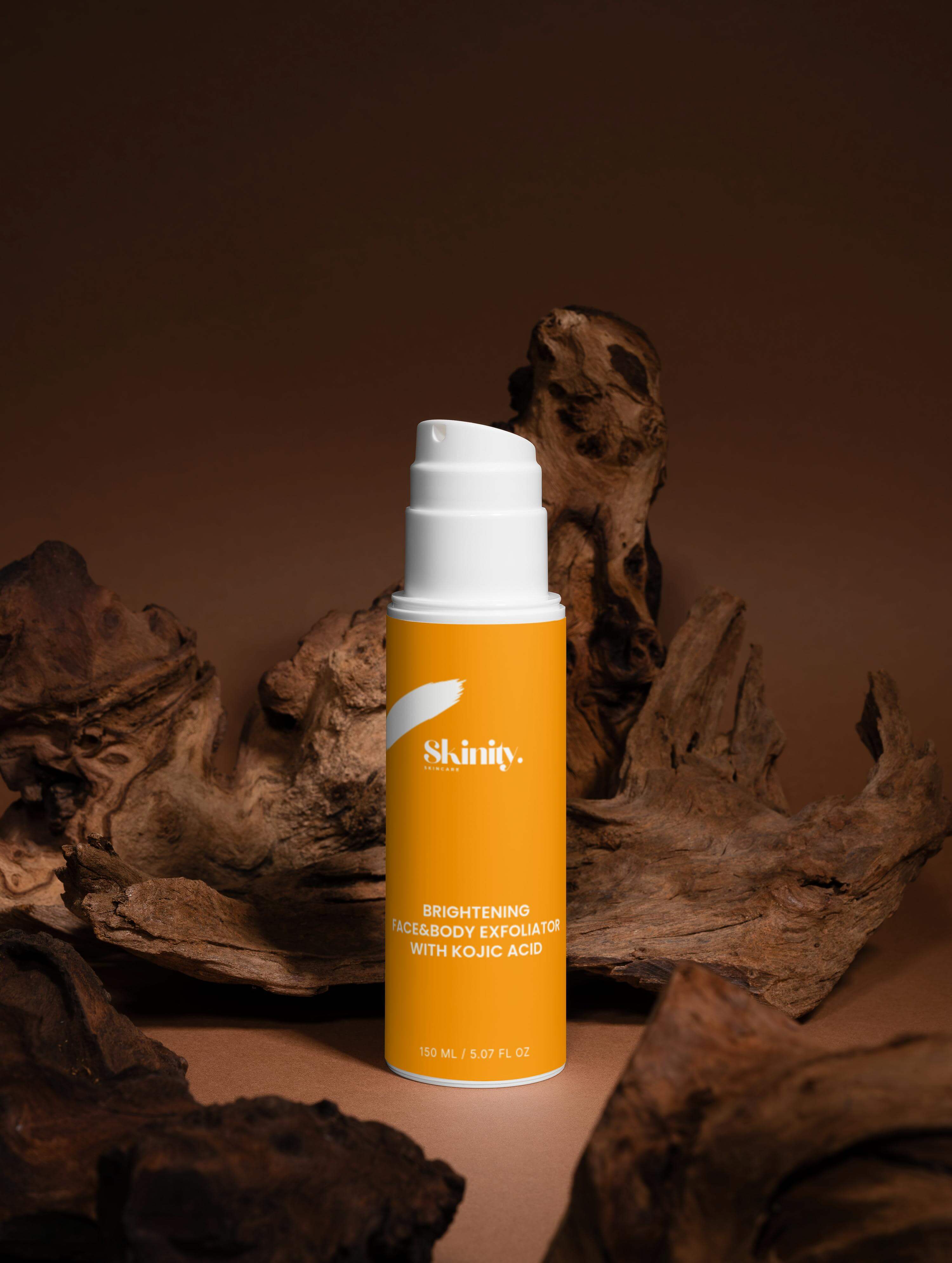 Brightening face and body exfoliator with kojic acid bottle on wooden background