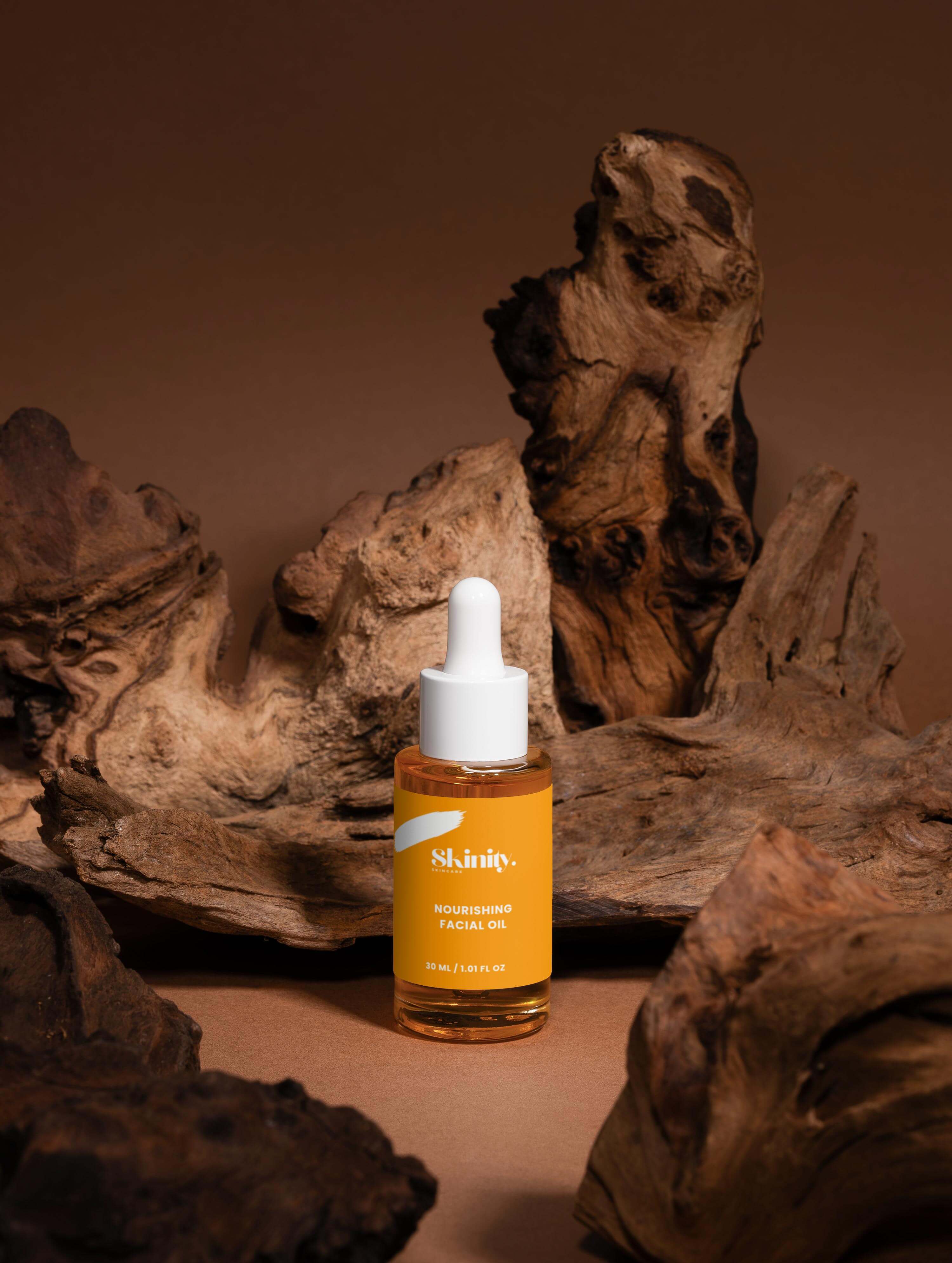 Nourishing facial oil for all skin displayed in a dropper bottle on a rustic wooden background.