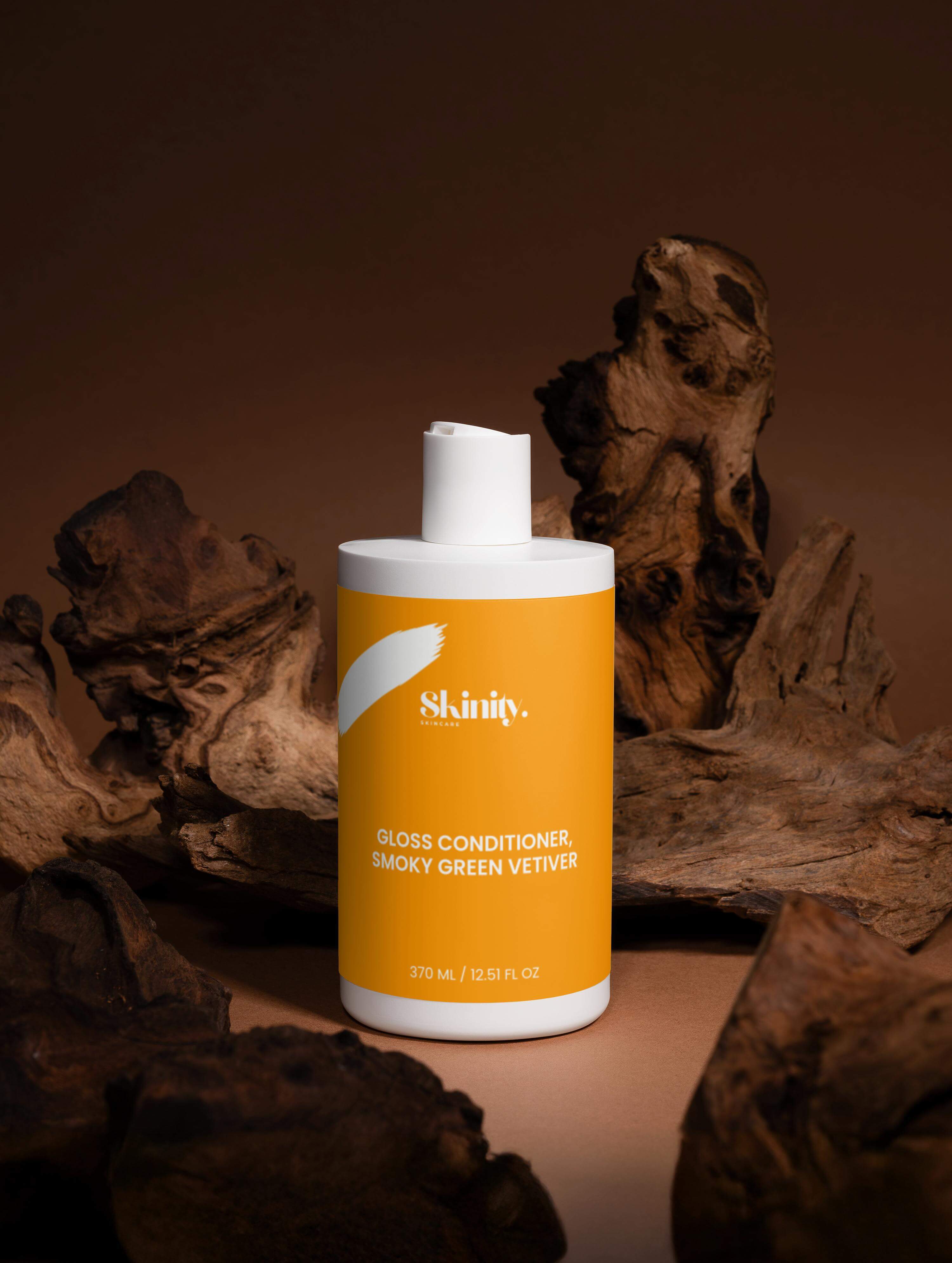 Gloss Conditioner Smoky Green Vetiver bottle on rustic wood background for nourished, silky hair.