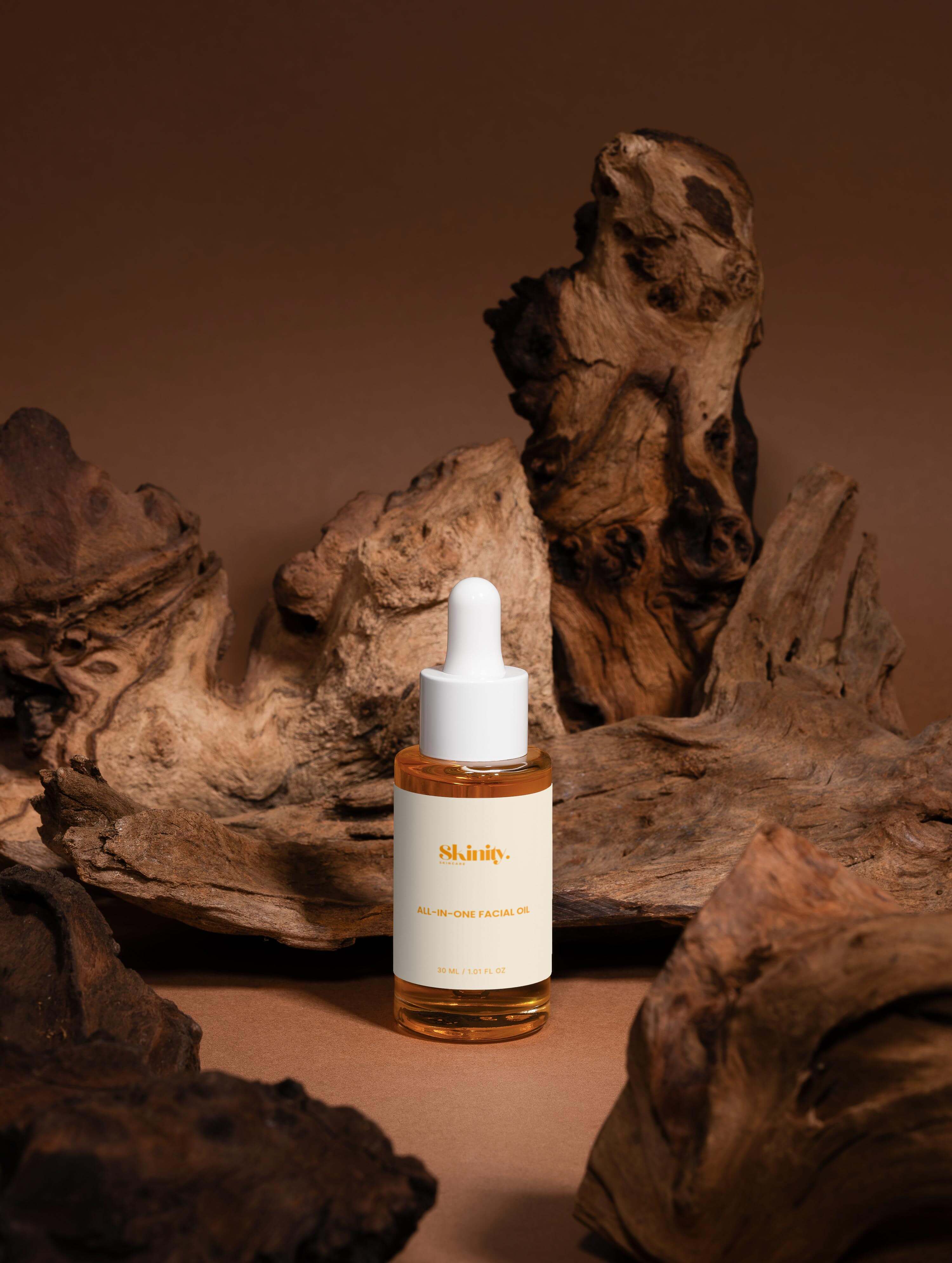 All-In-One Facial Oil for all skincare bottle displayed on textured wooden background.