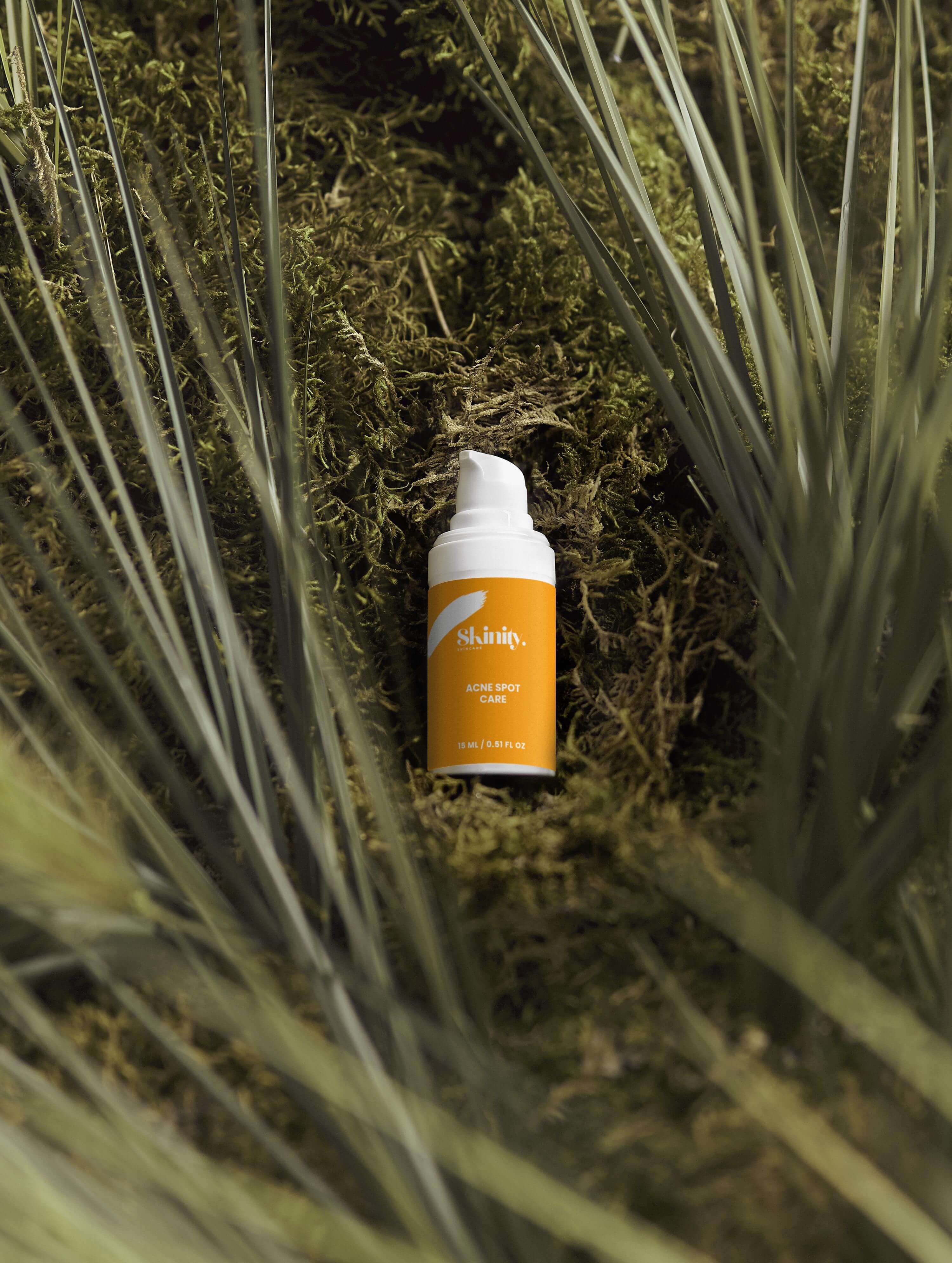 Acne Spot Care Serum for all skin types placed among natural greenery, showcasing its eco-friendly design.