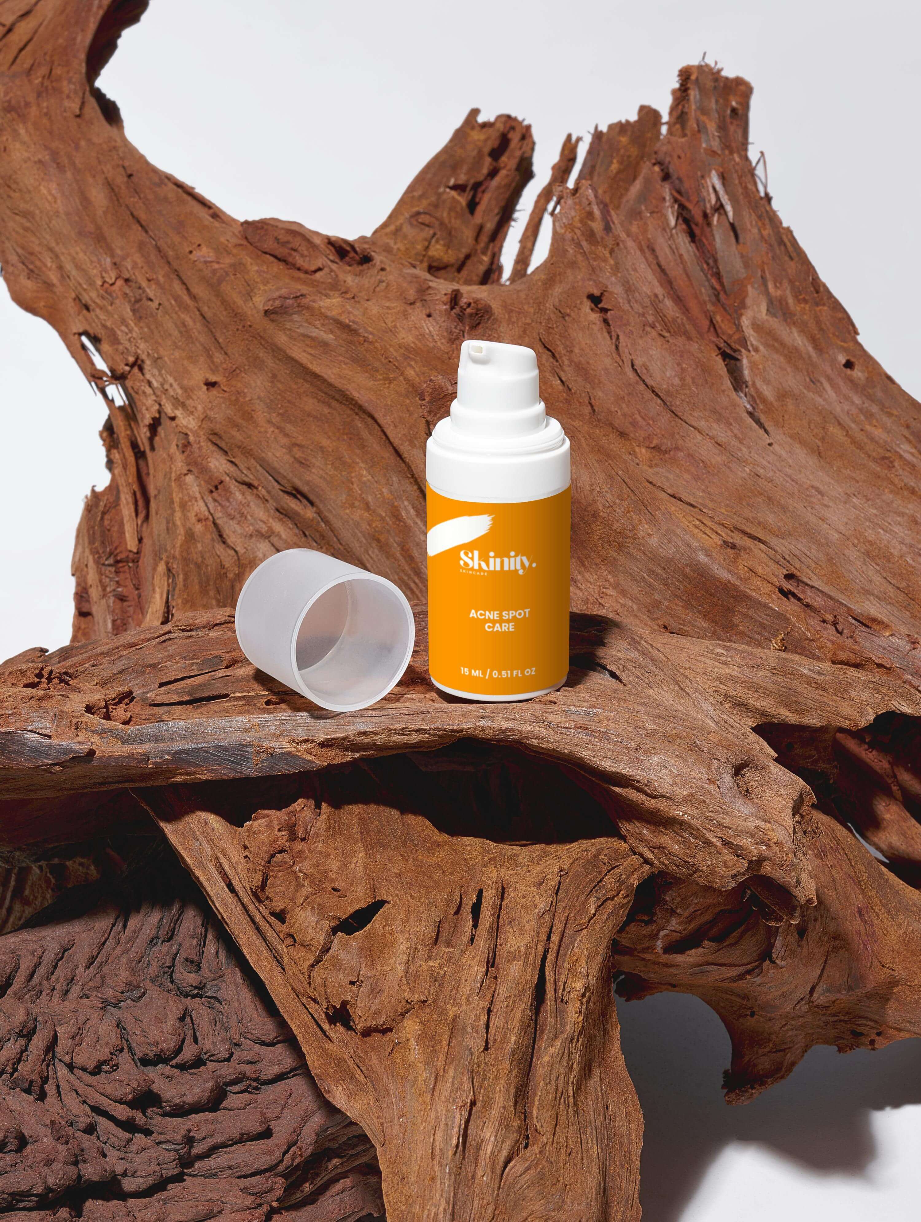 Acne Spot Care Serum for all skin types on wooden surface showcasing eco-friendly packaging.