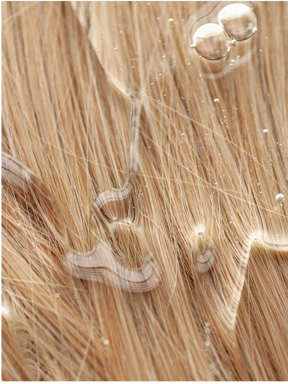 Gloss Shampoo Smoky Green Vetiver used on hair showing smooth and glossy texture with water droplets.