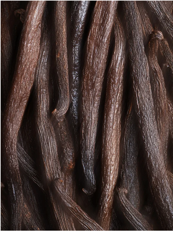 Close-up of dark, textured vanilla pods on a brown background.