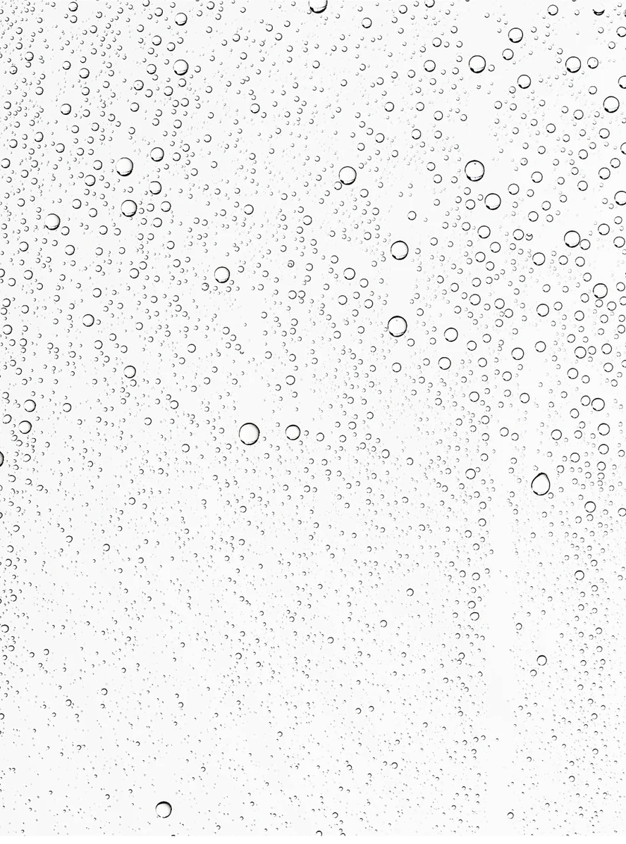 Water droplets on glass, representing hydration and freshness associated with Microbiome Prebiotics Face Mist.