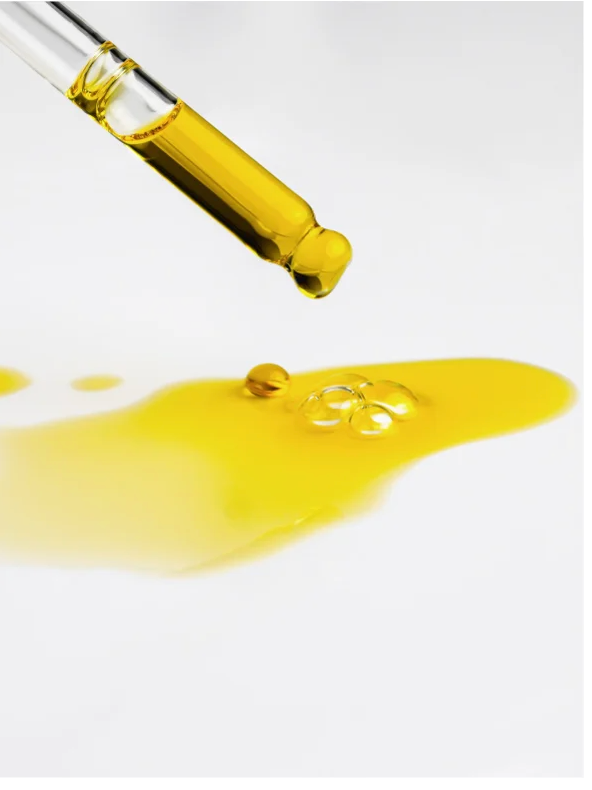 Natural Retinol Alternative Oil Serum dropper with golden serum on a white surface, highlighting its rich texture.