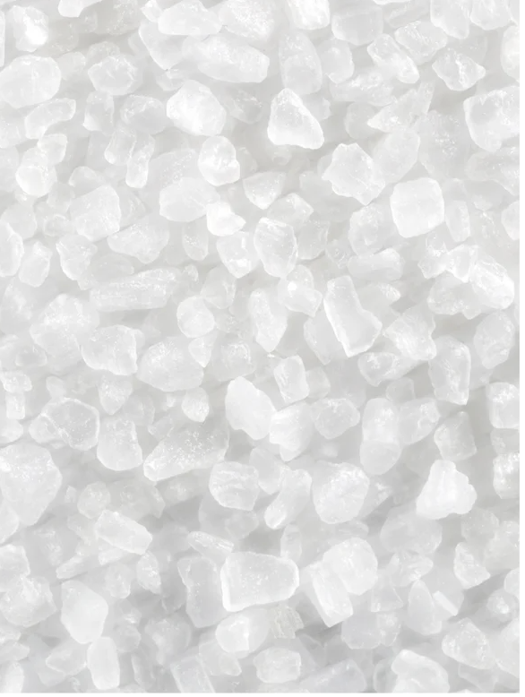Close-up of natural mineral salt crystals in various sizes, ideal for spa and skincare uses.