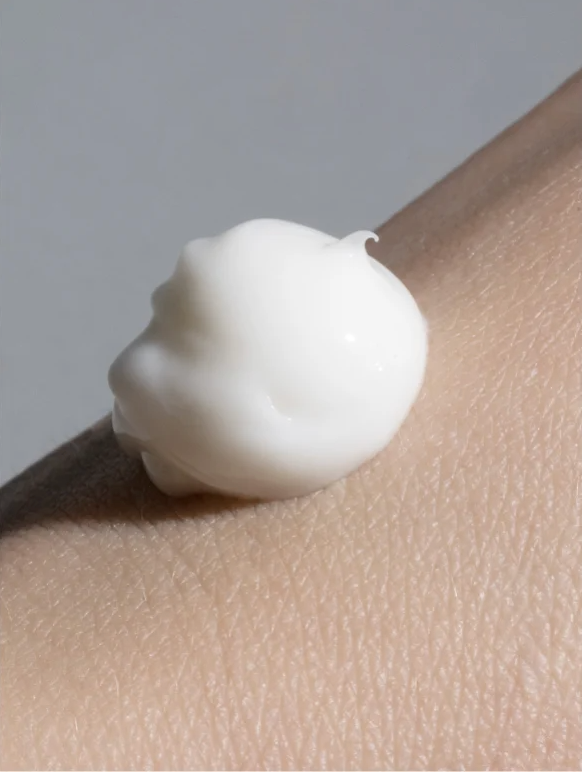 Silk Skin Hand Cream Woody Amber and Leather on a hand, showcasing creamy texture for hydration and nourishment.