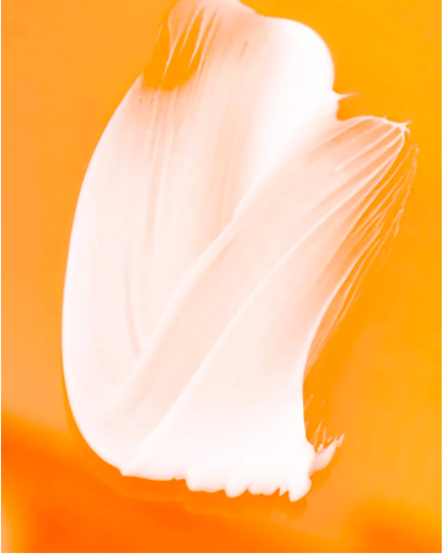 Brightening Eye Cream for All skincare swatch on vibrant orange background.