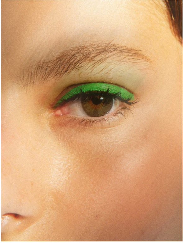 Close-up of an eye with vibrant green eyeliner showcasing artistic makeup.