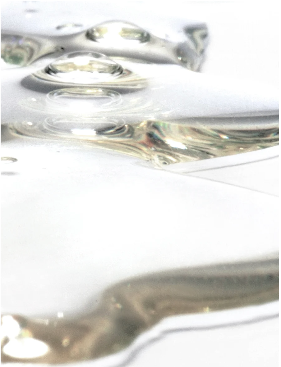 Close-up of a clear, glossy texture representing the Caffeine Gel Booster for All Skin.