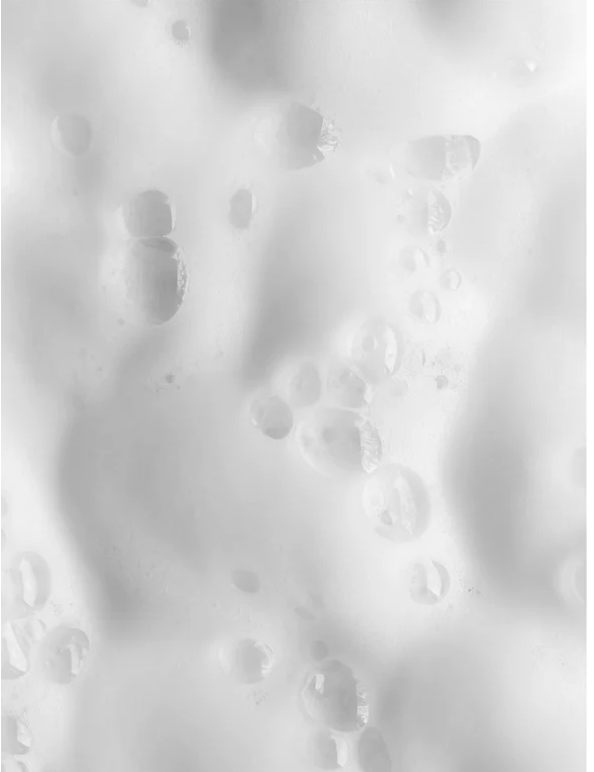 Cleansing Foam for all skincare with soft, bubbly texture and water droplets on a clean surface.