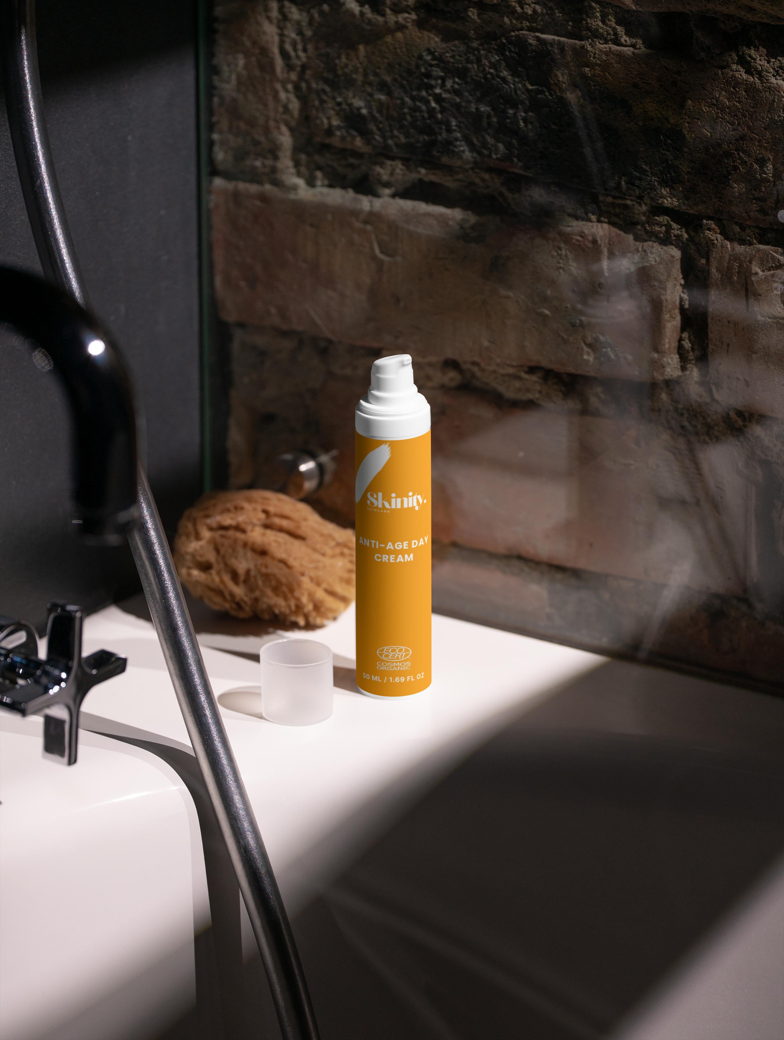 Anti-Age Day Cream For All Skin displayed on a bathroom sink with a natural sponge nearby.