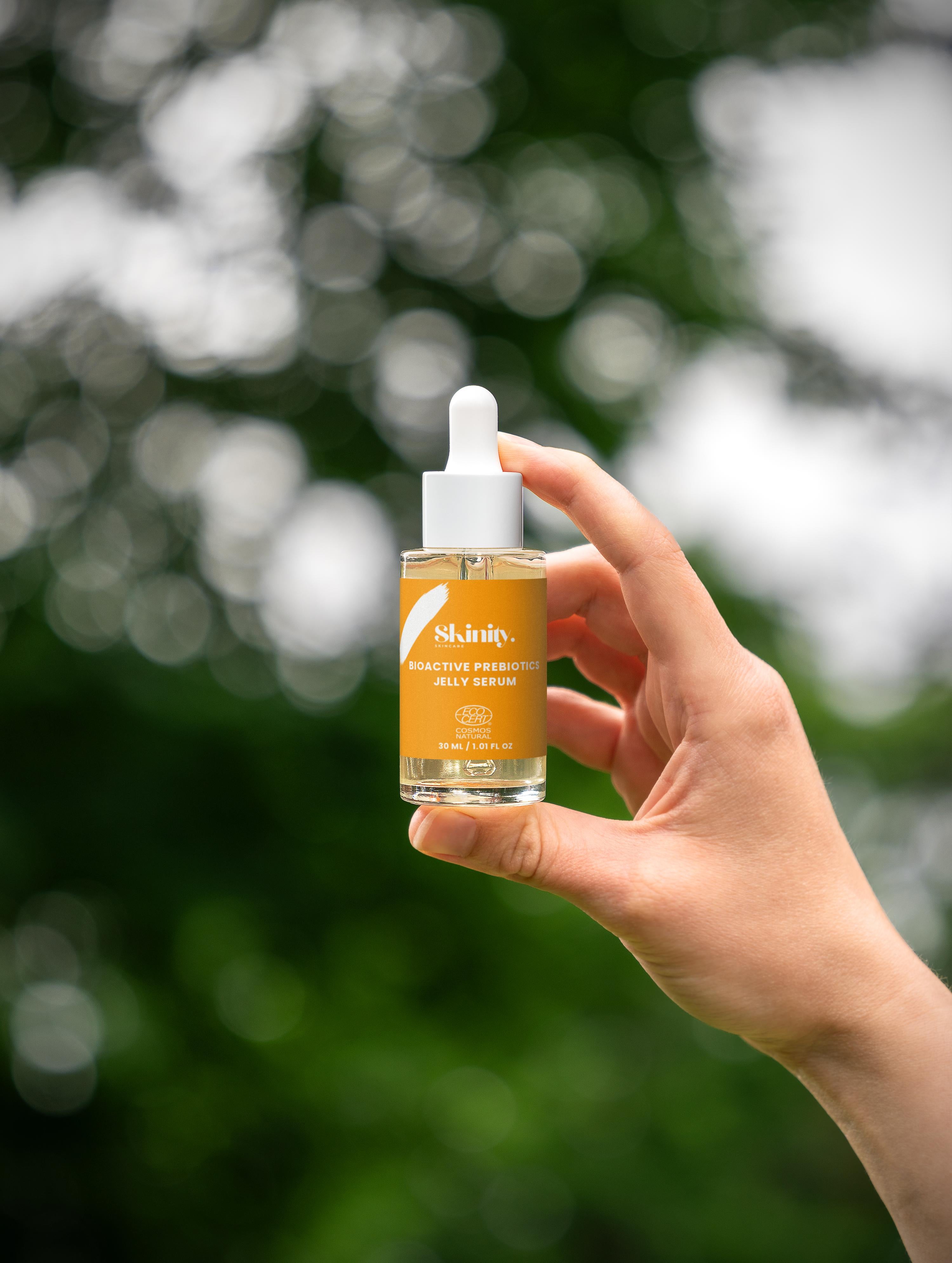 Bioactive Prebiotics Jelly Serum held in hand, showcasing its natural and eco-friendly qualities outdoors.