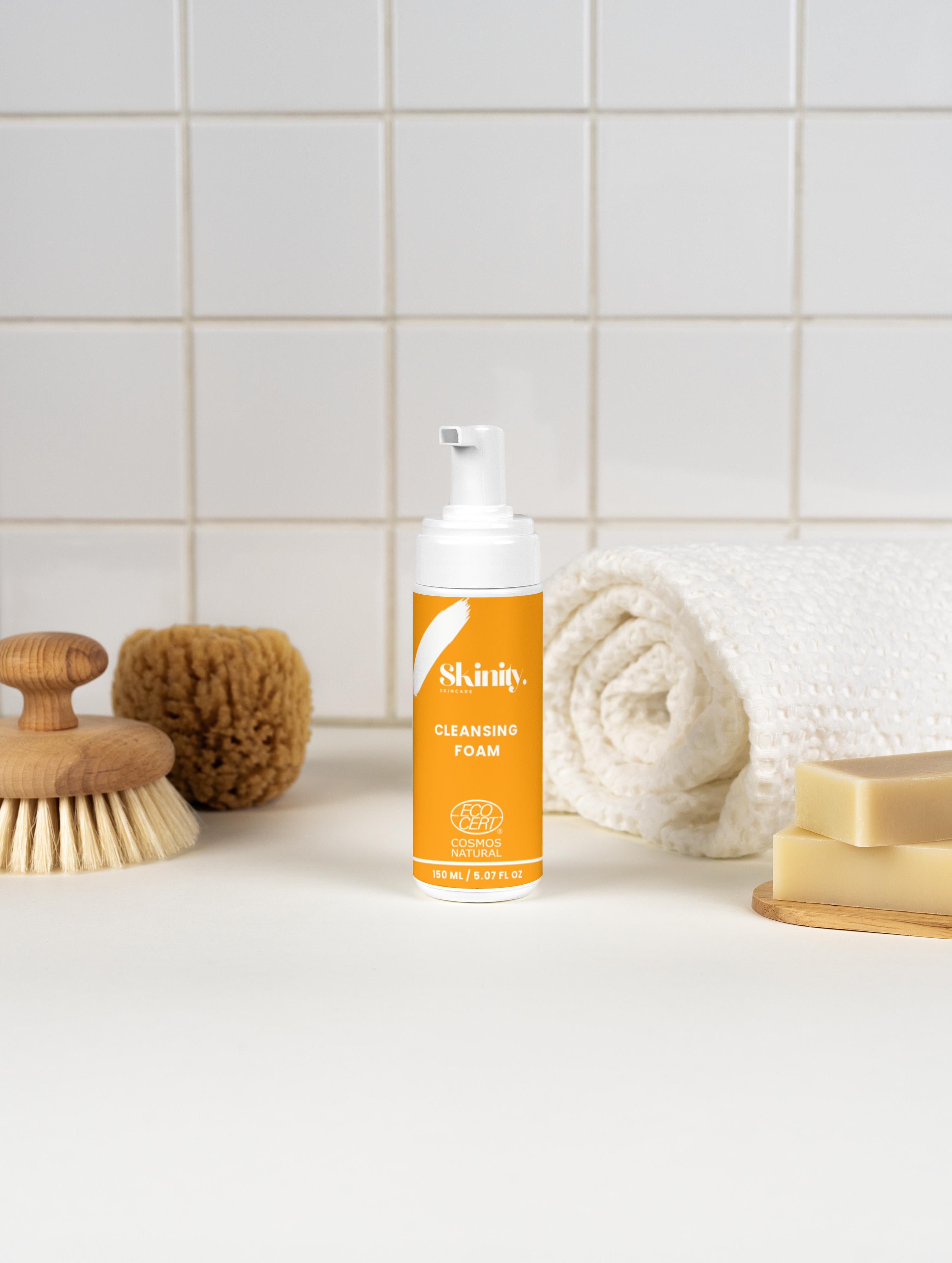Cleansing Foam for all skincare displayed on a countertop with brushes and towels.
