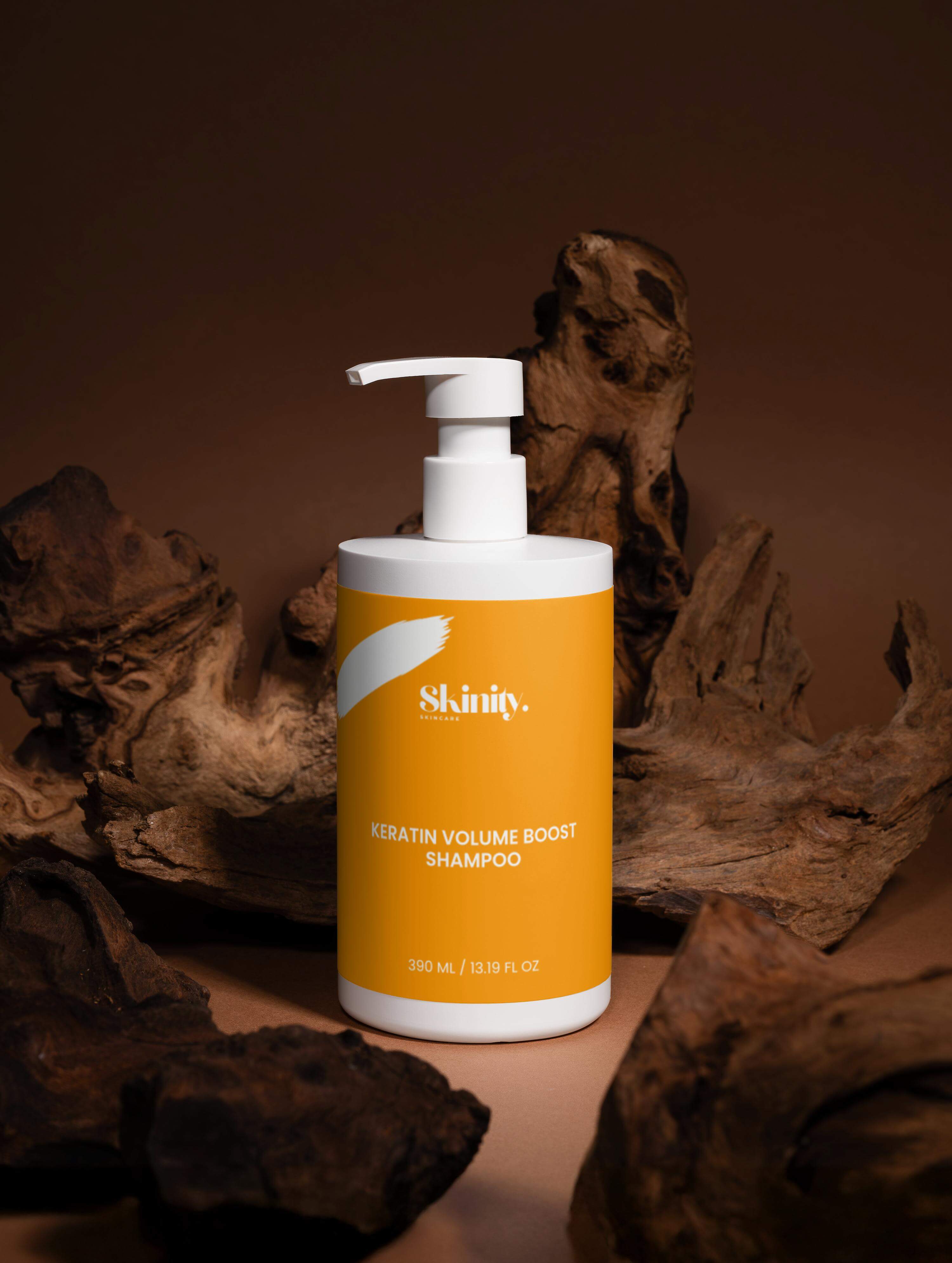 Keratin volume boost shampoo for all hair types in a white bottle on a natural wood background.