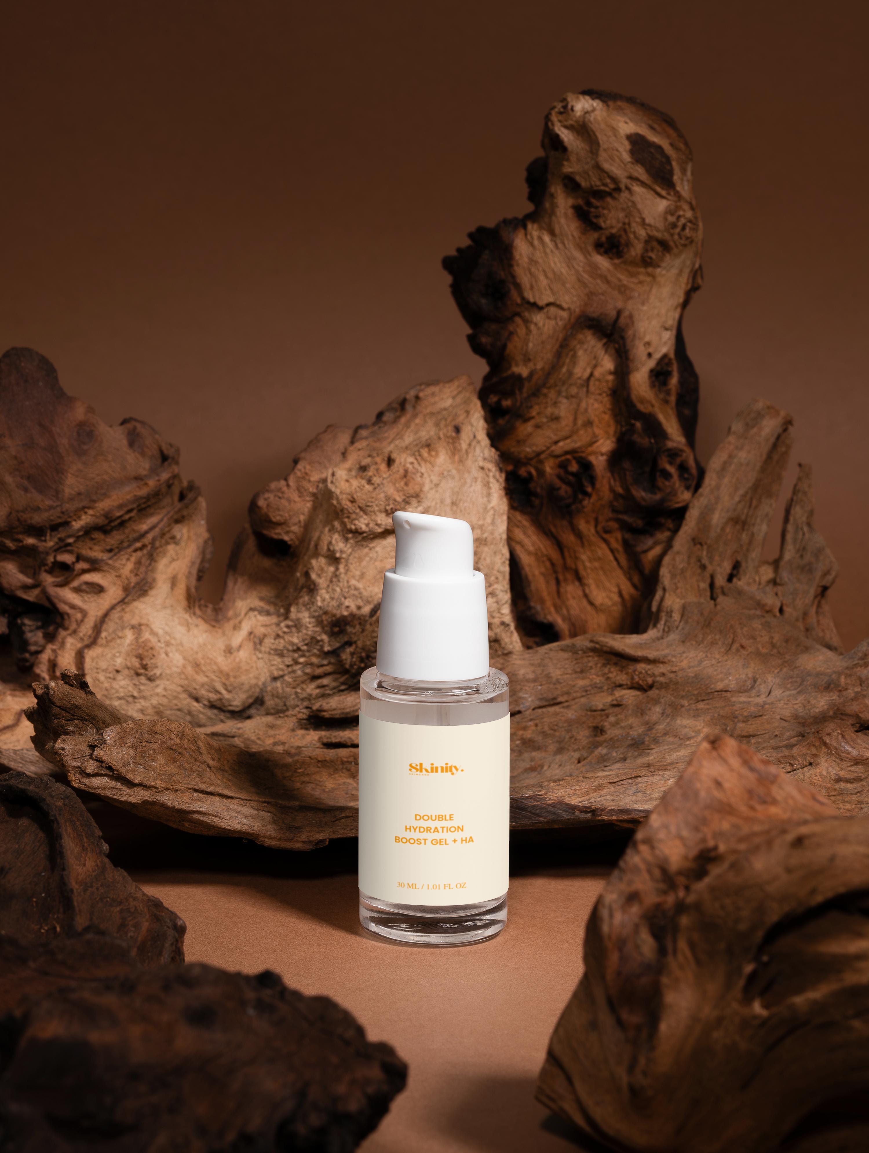 Double hydration boost gel + HA in a clear bottle on textured wooden background.