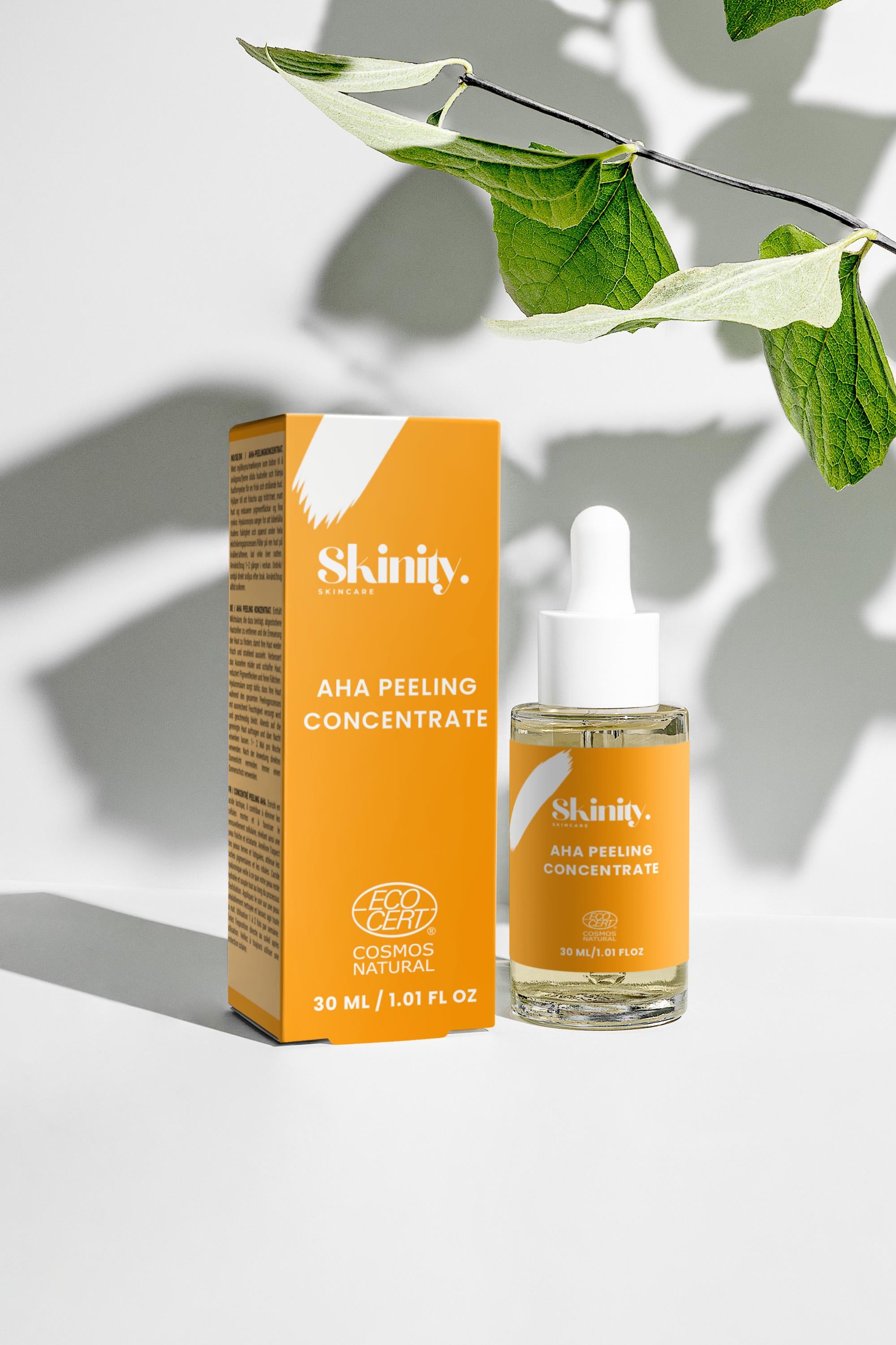 AHA Peeling Concentrate For Skincare in a bottle with dropper next to its orange packaging with green leaves.